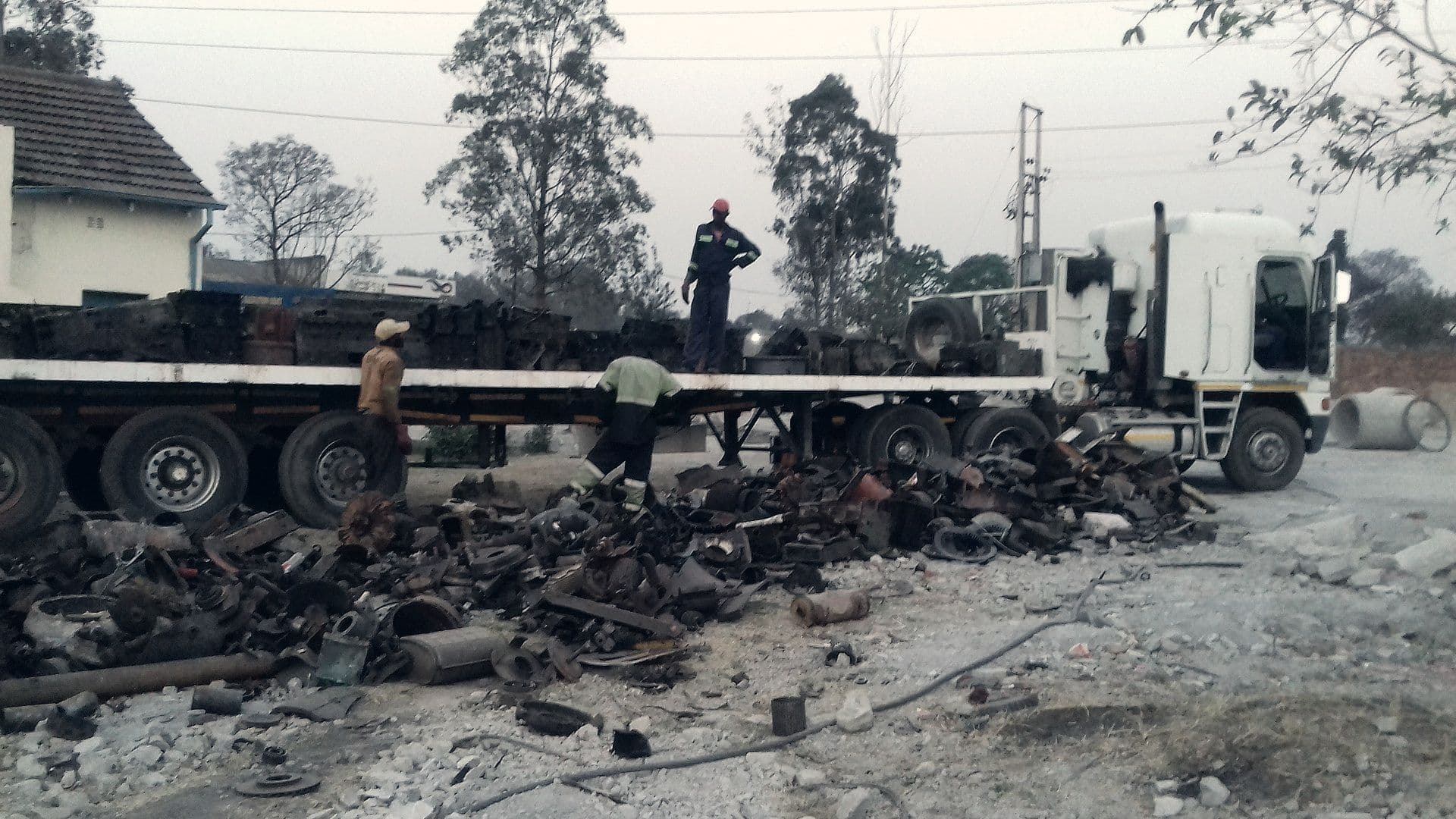 Workers loading scrap metal onto a flatbed truck