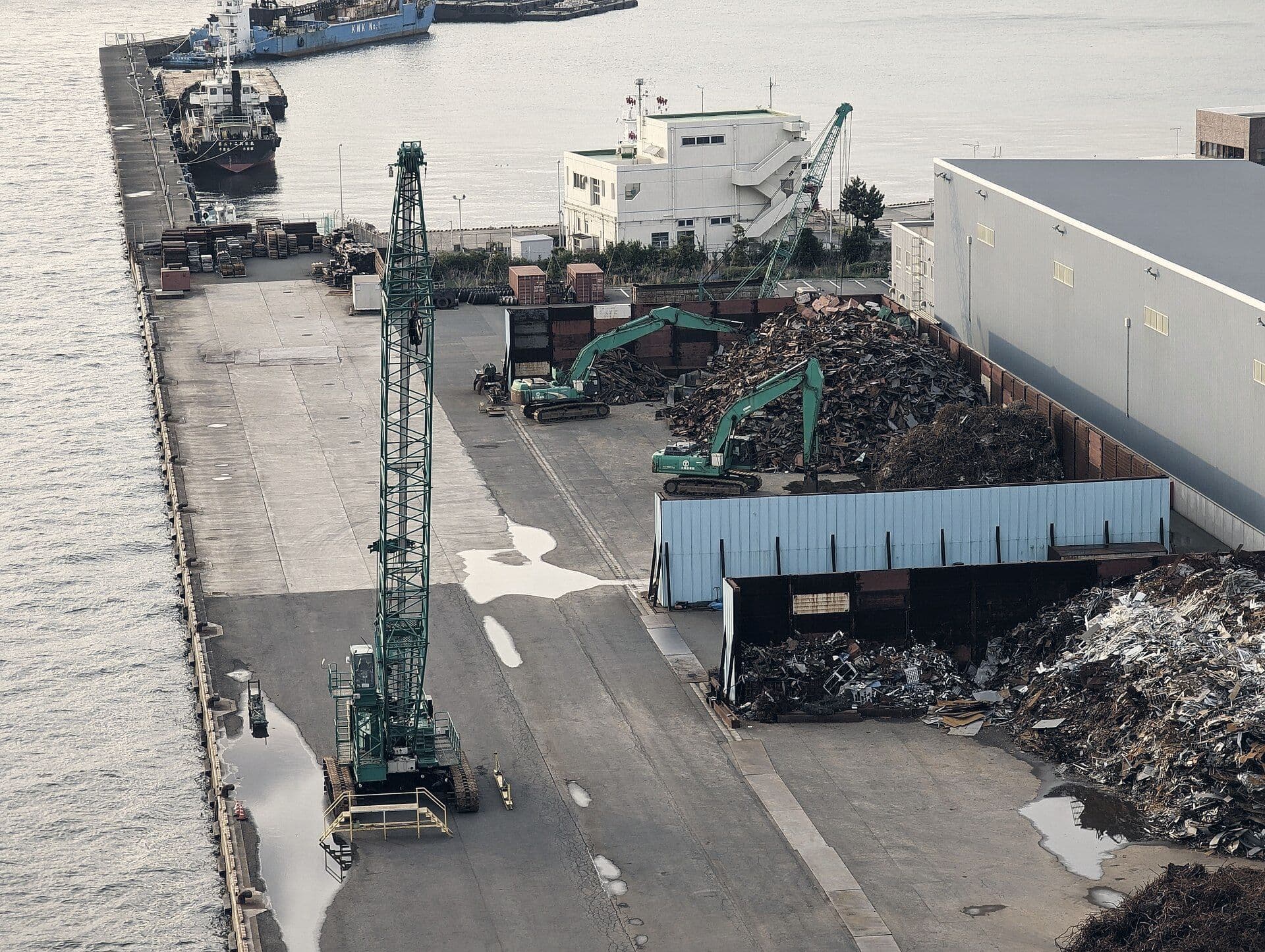 Aerial view of a scrap yard with cranes beside the water